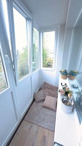 a small room with a table and two windows at Arena apartment in Panevėžys