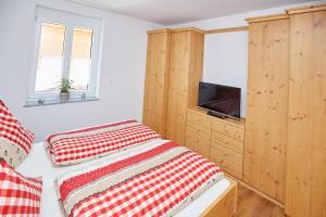 オーベルストドルフにあるOberstdorfer Bergwelt Herbersのベッドルーム1室(赤と白の枕が備わるベッド1台付)