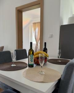 a table with two bottles of wine and glasses at Apartmani Tara House in Milekići