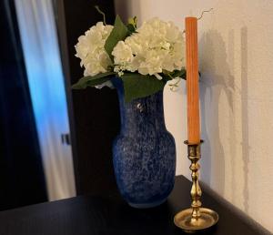 a blue vase with white flowers and a candle on a table at Villa Di Mare in Mesimvría