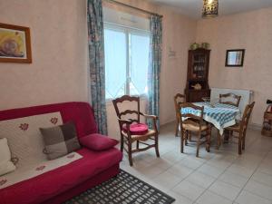 a living room with a red couch and a table and chairs at Pré en Bulles in Trépail +24 photos