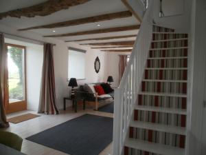 Gites du Manoir في Runan: غرفة معيشة بها درج وأريكة