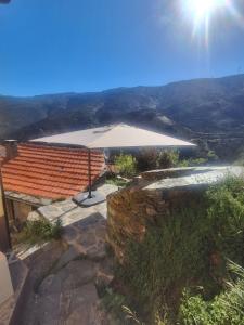 an umbrella sitting on a patio with a view at Casa das Cerejeiras in Pomares