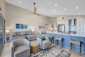 a kitchen and living room with blue and white cabinets at Captiva Hide A Way 2B in Captiva +26 photos