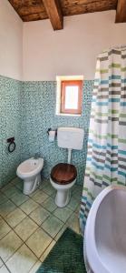 a bathroom with a toilet and a sink and a tub at Liana's home in Gallo +44 photos