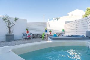 a swimming pool in a backyard with a table and chairs at Lagadi Suites Mesaria in Mesaria