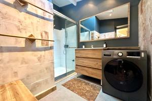 a washer and dryer in a bathroom with a shower at Retraite cosy aux portes de la Baie de Somme in Abbeville