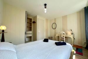 a bedroom with a large white bed and a desk at Retraite cosy aux portes de la Baie de Somme in Abbeville +13 photos