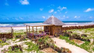 a small hut on a beach with the ocean at Dhahabu Village - Villa 244 Beachfront stay in Mambrui