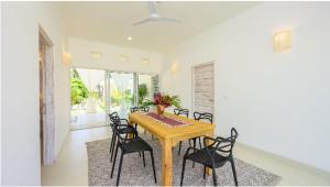 a dining room with a wooden table and chairs at Dhahabu Village - Villa 244 Beachfront stay in Mambrui