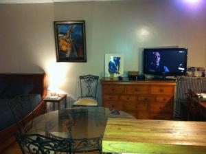 a living room with a table and a tv on a dresser at Alibert1er in Paris