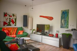 a living room with a green couch and a flat screen tv at Mainresidenz Wertheim in Wertheim