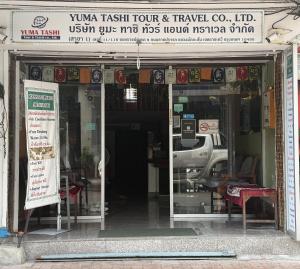 a store front of a car dealership with a sign at Yuma Tashi Hostel in Bangkok