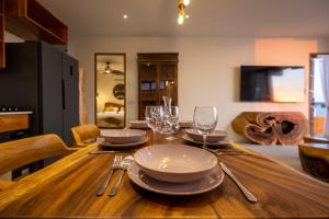 a wooden table with plates and wine glasses on it at Villa Kinnari in Ko Phangan +52 photos