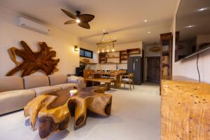 a living room with a wooden coffee table and a kitchen at Villa Kinnari in Ko Phangan