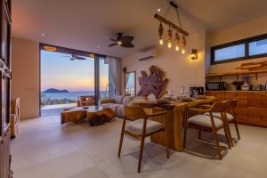 a kitchen and living room with a view of the ocean at Villa Kinnari in Ko Phangan