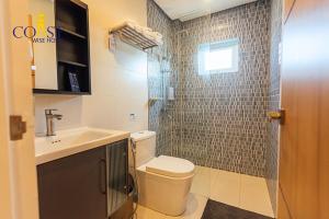 a bathroom with a toilet and a sink and a shower at Coast Wise Hotel Dumaguete in Dumaguete +24 photos