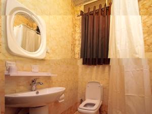 a bathroom with a sink and a toilet and a mirror at St Augustine Apart & Hotel in Kigali