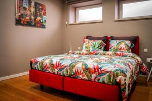 a bedroom with a red bed with a colorful comforter at IDDup Atrium in Oreye