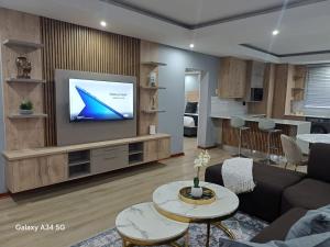a living room with a tv on a wall at Uptown Apartments - Casalinga Villas in Mataffin