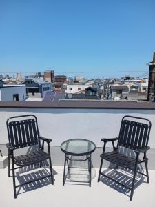 two chairs and a glass table on a roof at 3 Free Rental Bicycles - Free Parking - 85sqm - Up to 9 Guests - 7min to Koreatown - Japanese Lessons by Professional teacher - 自転車3台無料貸出 - 無料駐車場 - 85平米 - 定員9名 - コリアタウン徒歩7分 - Mintak Katsuyama V Residence in Osaka