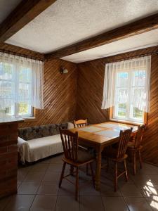 ein Esszimmer mit einem Holztisch und Stühlen in der Unterkunft AGRO-CHATKA in Myszyniec