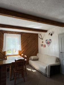 ein Schlafzimmer mit einem Bett, einem Tisch und einem Fenster in der Unterkunft AGRO-CHATKA in Myszyniec