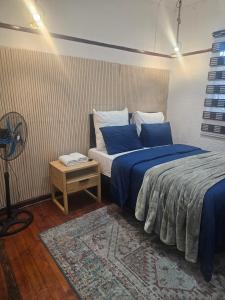 a bedroom with two beds with blue sheets and a table at 1krom str bellville boston in Bellville