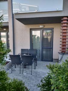a patio with chairs and a table in front of a building at Apartmany Arcadia in Podhájska
