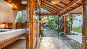 an outdoor bedroom with a bed and a patio at Diva Villa Sanggingan Ubud in Ubud