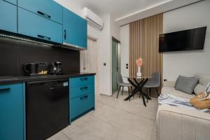 a kitchen and living room with blue cabinets and a couch at Moon Boutique Hotel - Ultra Luxury Suites with Pool, Perfect for Fun and Relaxation By Villa Mana Gers in Laganas