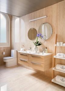 a bathroom with a sink and a toilet and mirrors at Halcyon Days designer apartments by Ana Locking in Málaga