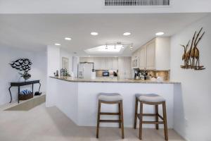 a kitchen with a counter and two bar stools at Beachcomber A101 in Sanibel