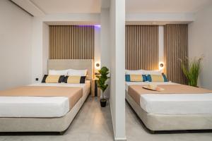 two beds in a hotel room with two beds at Moon Boutique Hotel - Ultra Luxury Suites with Pool, Perfect for Fun and Relaxation By Villa Mana Gers in Laganas +52 photos