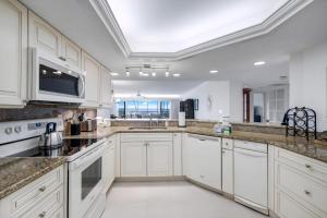 a large white kitchen with white cabinets and a sink at Beachcomber A101 in Sanibel
