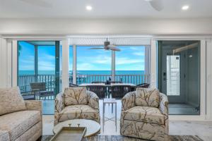 a living room with a couch and chairs and a balcony at Captiva Hide A Way 1B in Captiva +24 photos