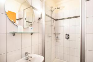 a bathroom with a shower and a sink and a mirror at Ferienhaus Gut Düneburg in Haren +23 photos