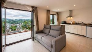 a living room with a chair and a large window at Hotel Kavia Sarria in Sarria