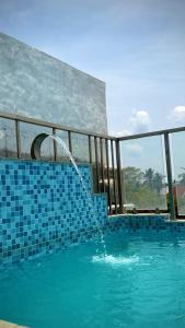 a swimming pool with a water fountain in it at Serenity Beach Inn in Pondicherry