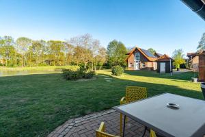 a patio with a table and chairs in a yard at Ferienhaus Gut Düneburg in Haren