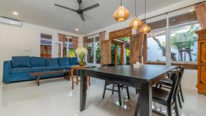 a dining room with a blue couch and a table at Diva Villa Sanggingan Ubud in Ubud