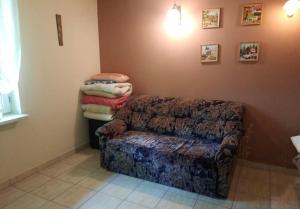 a living room with a couch and a pile of towels at Domek Letniskowy in Radawa