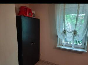 a black cabinet in a room with a window at Domek Letniskowy in Radawa