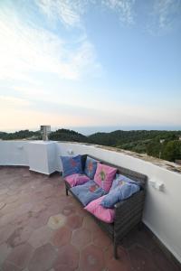a wicker couch with pillows sitting on a balcony at Torre Biancaluna in Vico del Gargano