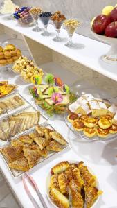a buffet filled with different types of pastries and desserts at Al-Xorazmiy Hotel in Urganch +33 photos