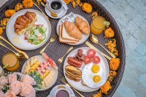 a table with plates of breakfast foods and drinks at Breathe Boutique Suites in Uluwatu