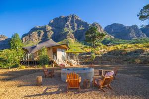 a group of chairs and an umbrella in front of a house at Camp Canoe in Franschhoek