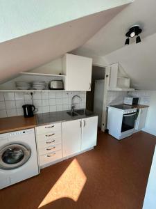 a kitchen with a sink and a washing machine at Halek Hem - Haga Nest in Haga +4 photos