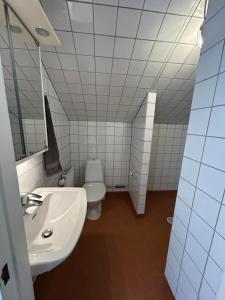 a bathroom with a white sink and a toilet at Halek Hem - Haga Nest in Haga