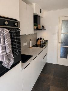 a kitchen with white cabinets and a black stove top oven at Appartement Bongerdstraat in Nijmegen